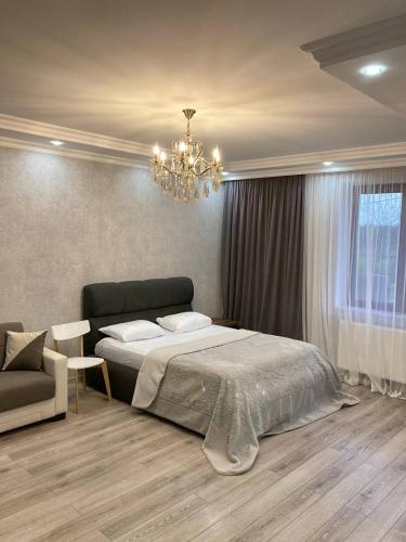 a bedroom with a bed and a chandelier at Riverside Cottage Poti in Poti