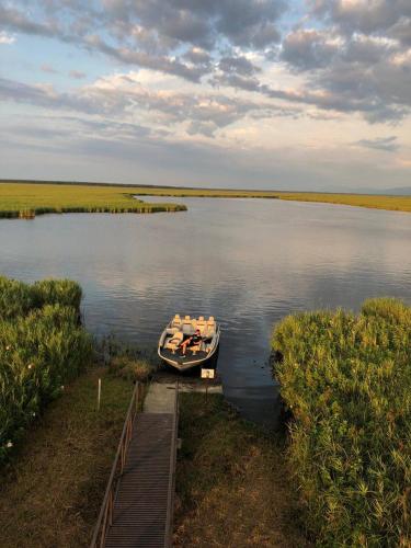 a boat is docked at a dock on a lake at Riverside Cottage Poti in Poti