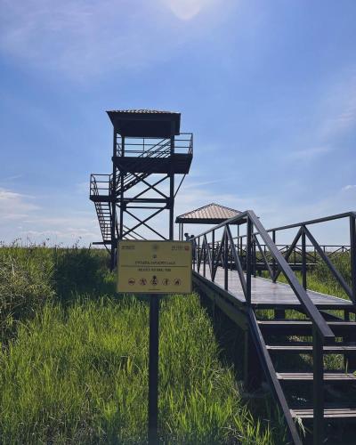 a sign in the grass next to a wooden bridge at Riverside Cottage Poti in Poti