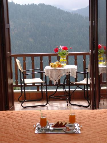 a table with a plate of food on a balcony at Ξενοδοχείο ΜΑΓΚΙΩΣΗ in Neraïdochóri