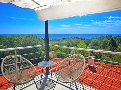 a balcony with two chairs and a view of the ocean at Hotel Amfora in St. St. Constantine and Helena