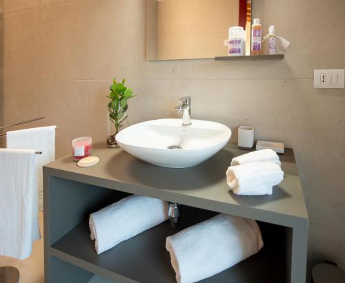 a bathroom with a sink and towels on a counter at Agri-alloggio le Poscole Al Canton in Castelgomberto