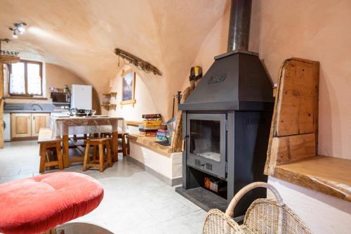 - un salon avec un poêle à bois dans la cuisine dans l'établissement Chalet De Charme à la Montagne, à La Lechere
