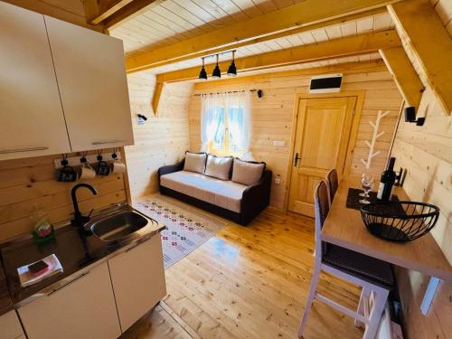 a kitchen and living room in a log cabin at DURMITOR APARTMAN Pitomine in Žabljak
