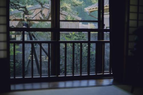 an open window with a view of a tree at 旅館依山盡イサンジン in Maniwa