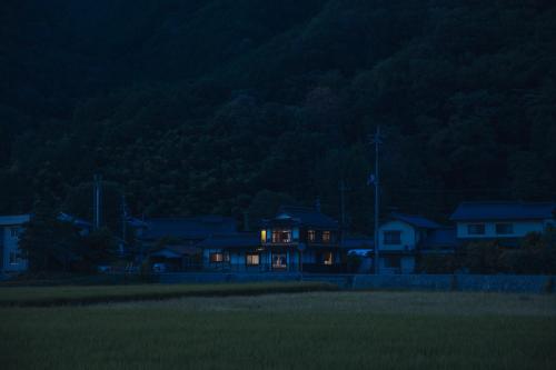 a house lit up at night with lights on at 旅館依山盡イサンジン in Maniwa