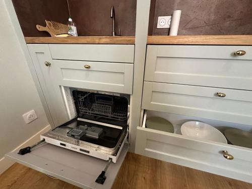 une cuisine avec un lave-vaisselle ouvert dans une armoire dans l'établissement Acquatignese Charme Authentique au Cœur de Bastia, à Bastia