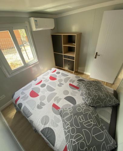 a bedroom with a bed with a comforter and pillows at Gite Le Panoramique in Dumbéa