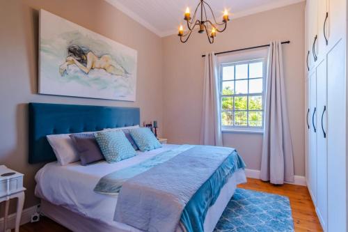 a bedroom with a large bed and a window at Blue Bell in Hermanus