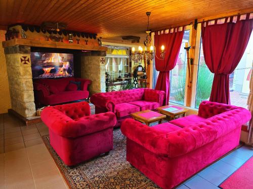 a living room with red furniture and a fireplace at Ostsee-Rittergut-Rügen mit BinzHotel & OrdensKapelle & RomantikGut in Binz