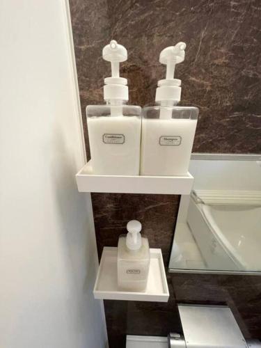 two white toothbrushes on a shelf in a bathroom at 羽田5丁目 in Tokyo