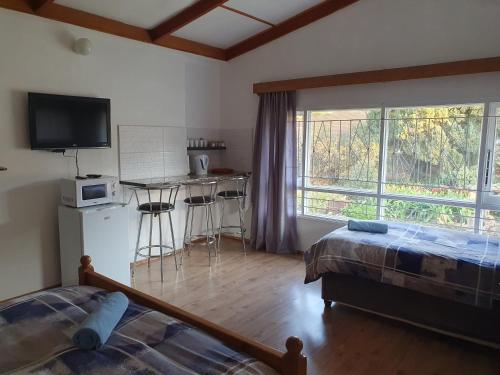 Cet appartement comprend une chambre avec un lit et une cuisine avec une fenêtre. dans l'établissement Nandi's Place, à Harrismith