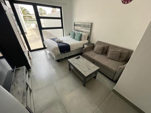 a living room with a couch and a coffee table at Fischreiher Seaside Self Catering Studio Apartment in Swakopmund