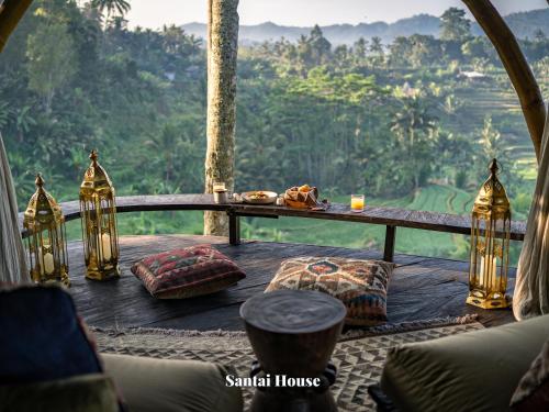 a room with a table and a view of a forest at Camaya Bali - Magical Bamboo Houses in Selat