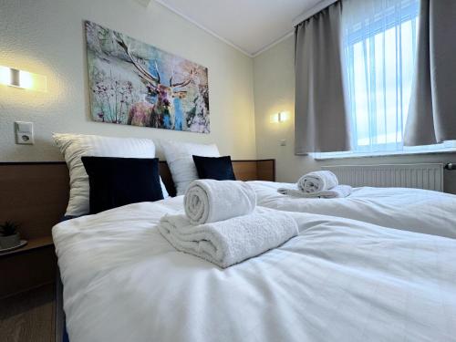 a bedroom with two beds with towels on them at REGIOHOTEL Salzland Schönebeck in Frohse