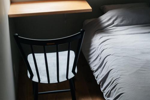 a black chair sitting next to a desk next to a bed at 紅花舎 koukasha in Yamaguchi