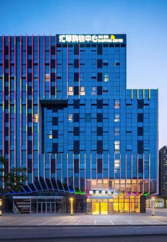 a large blue building with a sign on top of it at Dream Inn Hotel Beijing in Beijing