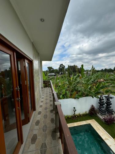 a house with a swimming pool and a balcony at Nyoman House in Tabanan