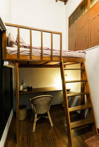 a room with two bunk beds and a chair at SOLO - Fong Lee CC Lampang Walking Street in Lampang