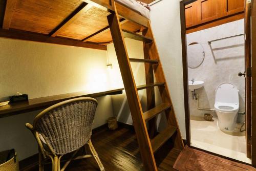 a small room with a toilet and a chair at SOLO - Fong Lee CC Lampang Walking Street in Lampang