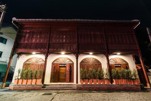 a building with wooden doors and plants in front of it at SOLO - Fong Lee CC Lampang Walking Street in Lampang