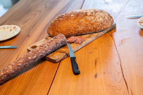 a wooden table with a knife and a loaf of bread at Fjordhaus Edersee in Edersee