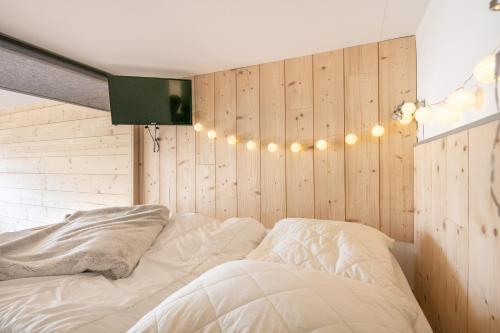 a bedroom with a bed with lights on the wall at Le Cocon d'Edwige - Vue montagne in Chamrousse