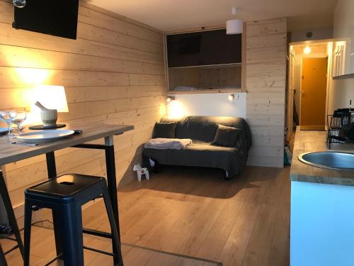 a living room with a couch and a table at Le Cocon d'Edwige - Vue montagne in Chamrousse