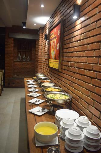 a long buffet line with plates and bowls of food at Abhaya Mandapa in Anuradhapura