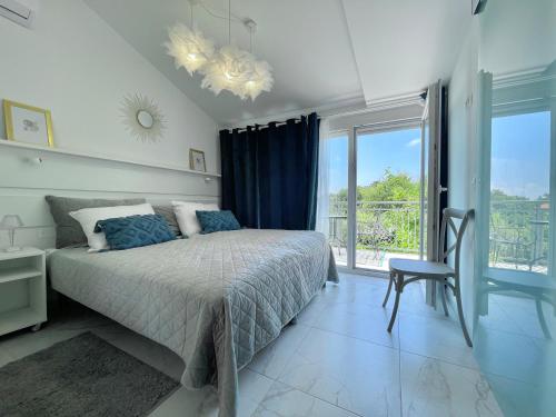 una camera da letto con un letto e una grande finestra di Villa AMore Radini with a private heated saltwater pool and private parking a Brtonigla (Verteneglio)