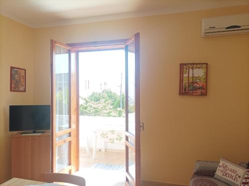 a living room with a door open to a patio at Dimora Relax in Torre dell'Orso