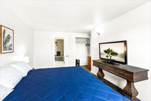 a bedroom with a blue bed and a television on a table at High Dunes Condos in Ocean Shores