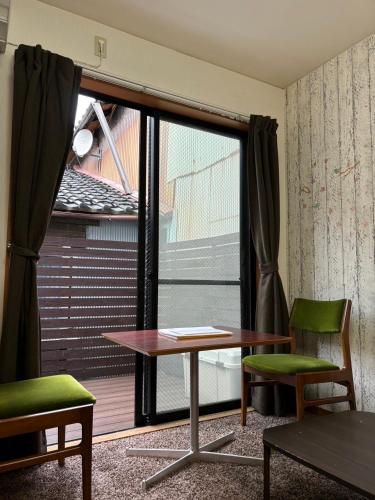 a room with a table and chairs and a window at Hummingbird Kanazawa in Kanazawa