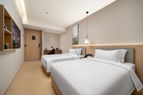 Una cama o camas en una habitación de X Hotel Shenzhen Convention and Exhibition Center Shixia Metro Station
