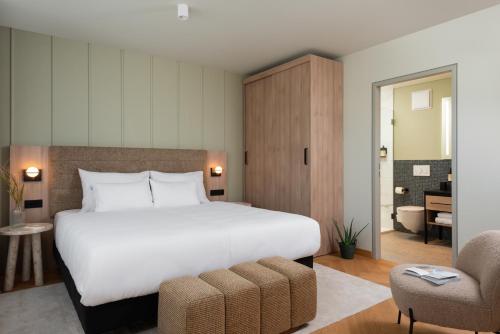 a bedroom with a large white bed and a chair at master Mirabell in Salzburg
