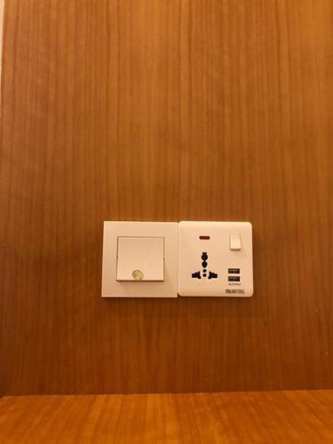 a white electrical outlet on a wooden wall at Nu Melati Hotel in Pantai Cenang