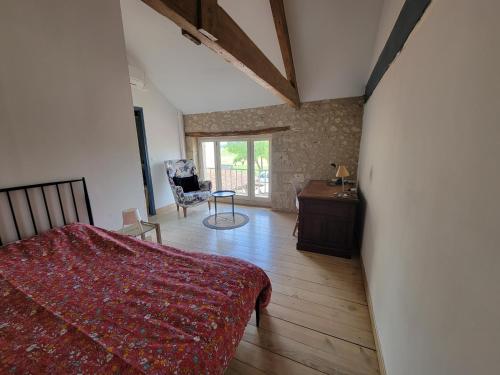 une chambre avec un lit, une table et une chaise dans l'établissement Gite 3, à Lauraët