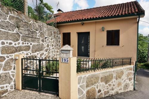 a house with a gate and a stone wall at Casa Valinhas in São Jorge