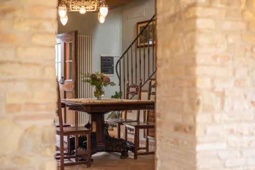 a dining room with a table and chairs and a staircase at Agriturimo Cà Dorale in Fano