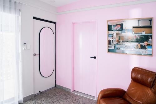 a room with a pink door and a leather chair at The Mysa Motel in Gold Coast