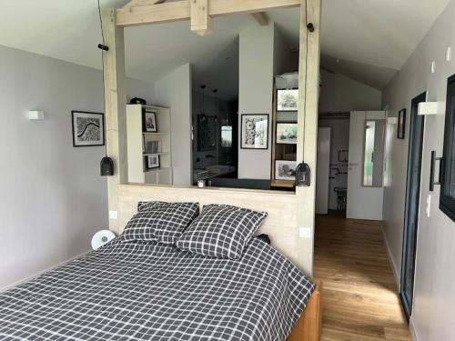 une chambre avec un lit et un grand miroir dans l'établissement Villa des Loriots, à Anglet