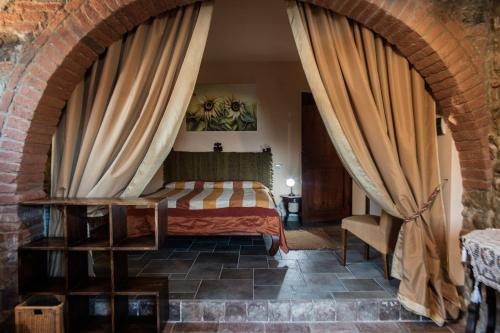 a bedroom with a bed in a brick wall at Villa Il Poggio in Sinalunga