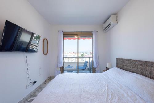 une chambre avec un lit et une télévision au mur dans l'établissement 1-Br Renovated Near Croisette, à Cannes