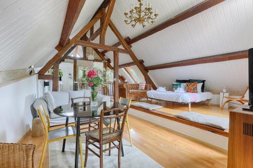 Zimmer mit einem Esstisch und einem Schlafzimmer in der Unterkunft Le Cottage à 10min de Disneyland Paris in Chalifert