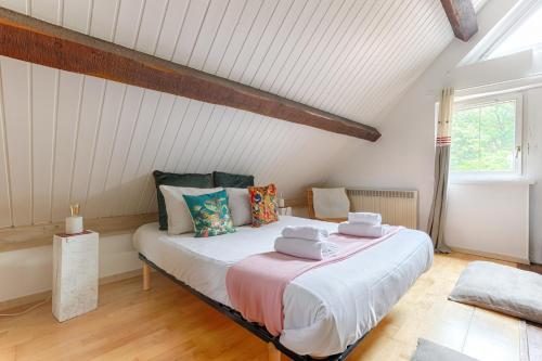 ein Schlafzimmer mit einem großen Bett im Dachgeschoss in der Unterkunft Le Cottage à 10min de Disneyland Paris in Chalifert