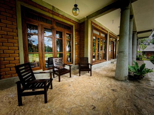 a porch with chairs and a table and windows at The Lotus Villa Sigiriya in Sigiriya