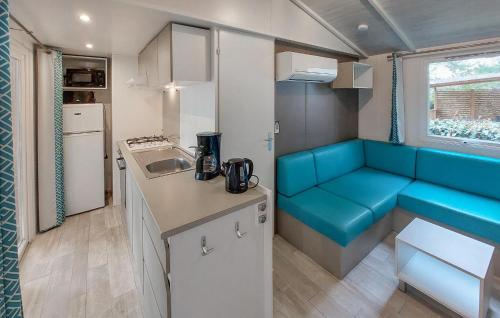 - une cuisine avec un canapé bleu dans une caravane dans l'établissement Mobile Home Moderne, à Saint-Hilaire-de-Talmont