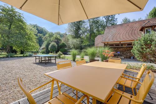 - une table et des chaises avec un parasol dans la cour dans l'établissement Le Cottage à 10min de Disneyland Paris, à Chalifert
