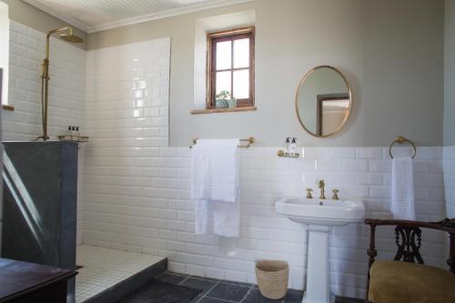 a white bathroom with a sink and a mirror at Seal Point Lighthouse in Cape St Francis