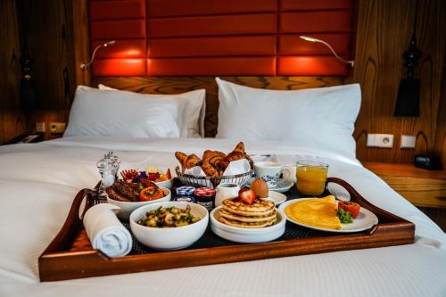 a tray of breakfast food on a bed at Hilton The Hague in The Hague